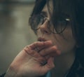 Portrait of pensive woman with misted glasses in dusk. Royalty Free Stock Photo