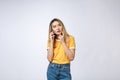 Portrait of a pensive young asian woman holding mobile phone and looking away thinking over white background Royalty Free Stock Photo