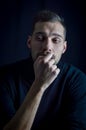 Portrait of a pensive young man biting his nails looking away Royalty Free Stock Photo