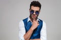 portrait of pensive young man wearing blue sunglasses and waistcoat Royalty Free Stock Photo