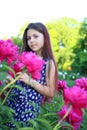 Portrait of a pensive young teen girl in a field with pink peonies Royalty Free Stock Photo