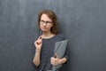 Portrait of pensive young woman holding folder and pen Royalty Free Stock Photo