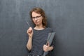 Portrait of pensive young woman holding folder and pen Royalty Free Stock Photo