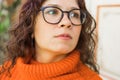 Portrait of pensive young woman smiling with urban background. Cheerful latin girl wearing eyeglasses in the city. Happy Royalty Free Stock Photo