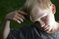 Portrait of pensive youngster (child blond boy) concentrated on something