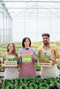 Portrait of people working in greenhouse in garden center, store open after lockdown. Royalty Free Stock Photo