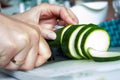 A portrait of a person cutting a courgette with a sharpp knife in a kitching while cooking a nice and delicious dinner. The Royalty Free Stock Photo