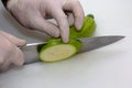 A portrait of a person cutting a courgette with a sharpp knife in a kitching while cooking a nice and delicious dinner Royalty Free Stock Photo