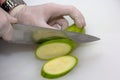 A portrait of a person cutting a courgette with a sharpp knife in a kitching while cooking a nice and delicious dinner Royalty Free Stock Photo