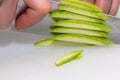 A portrait of a person cutting a courgette with a sharpp knife in a kitching while cooking a nice and delicious dinner Royalty Free Stock Photo