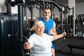 Portrait of person on a simulator in a gym. senior concept, a woman and a coach lead a healthy lifestyle, engage in Royalty Free Stock Photo