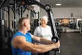 Portrait of person on a simulator in a gym. senior concept, a woman and a coach lead a healthy lifestyle, engage in Royalty Free Stock Photo