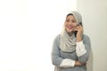 Portrait of a phappy successful asian muslim businesswoman call someone on mobile phone, talking and smiling, standing near