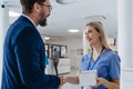 Pharmaceutical sales representative talking with doctor in medical building. Ambitious male sales representative Royalty Free Stock Photo