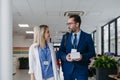 Pharmaceutical sales representative talking with doctor in medical building. Ambitious male sales representative