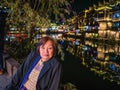 Portrait photo of Asian senior woman with beautiful nightscape of fenghuang old town. Royalty Free Stock Photo