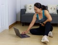 Portrait photo of beautiful adult 40 years old Asian woman in blue color Sports Clothing using Laptop for prepare Home Workout Royalty Free Stock Photo