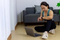 Portrait photo of beautiful adult 40 years old Asian woman in blue color Sports Clothing using Laptop for prepare Home Workout Royalty Free Stock Photo