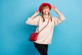 Portrait photo dreamy curious girl looking empty space in red hat smiling isolated vivid blue color background