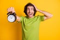 Portrait photo of man keeping alarm touching head deadline late amazed isolated on bright yellow color background