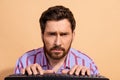 Portrait photo of nerd geek stressed programmer man using keyboard working remote overworked isolated on beige color Royalty Free Stock Photo