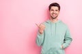 Portrait photo of positive cheerful guy wear khaki trendy sweater put hand pocket directing finger empty space tips