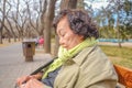 Portrait Photo of Senior asian women traveler sitting and relax in Temple of Heaven park or Tiantan in Chinese Name in beijing