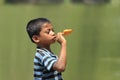 Portrait photo of a young boy enjoying his ice cream in the meadow during the summer holidays