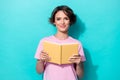 Portrait photo of young cute pretty woman wear pink t-shirt hold yellow book diary nerd isolated on cyan color Royalty Free Stock Photo