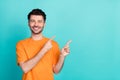 Portrait photo of young handsome positive confident nice man wear orange t-shirt fingers pointing empty space