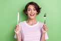 Portrait photo of young smiling happy positive angry woman hold knife fork smiling excited want eat some food isolated