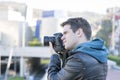 Portrait of photographer with camera in action in the street. Royalty Free Stock Photo