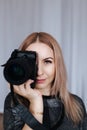 Portrait of a photographer covering her face with the camera. Royalty Free Stock Photo