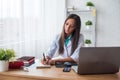 Portrait of physician doctor working in medical office workplace writing prescription sitting at desk. Royalty Free Stock Photo