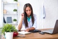 Portrait of physician doctor working in medical office workplace writing prescription sitting at desk. Royalty Free Stock Photo