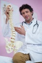 Portrait of physiotherapist sitting with spine model Royalty Free Stock Photo