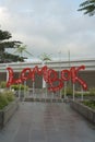 Portrait picture of red letter sign that says Lombok at Lombok International Airport.