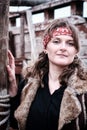 Portrait of a pirate woman in a red bandana, black shirt and fur jacket on the background of an old ship Royalty Free Stock Photo