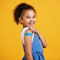 Portrait plaster and girl with smile, confidence and vaccination against a studio background. Face, Latino female child