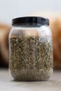 A portrait of a plastic pot or jar full of dried fresh viola tricolor leaves to set a fresh cup of tea. The herbs are ready to be Royalty Free Stock Photo