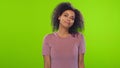 Portrait of african american young woman with curly hair flirts on green screen