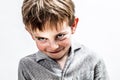 Playful boy smiling, looking mischievous for shy child humour Royalty Free Stock Photo