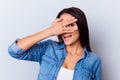 Portrait of a playful cute hispanic girl in casual clothes gesturing and posing, standing on the light vblue background Royalty Free Stock Photo