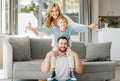 Portrait of playful and excited little boy sitting on his fathers shoulders and holding mothers hands while pretending Royalty Free Stock Photo