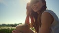 Portrait of playful girl smiling in sun reflection. Young woman playing hair. Royalty Free Stock Photo