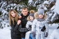 Portrait of playful happy family in winter snowy forest. Father and mother Royalty Free Stock Photo