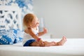 Portrait of playful toddler girl sitting on bed Royalty Free Stock Photo