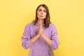 Woman keeping arms in prayer gesture and asking forgiveness, feeling sorry for mistake. Royalty Free Stock Photo