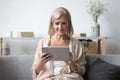 Portrait of pleasant middle aged woman using tablet. Royalty Free Stock Photo