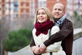 Portrait of pleasant smiling mature couple in city